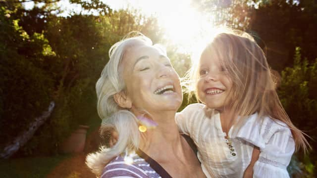 Abuela cargando a su nieta felices