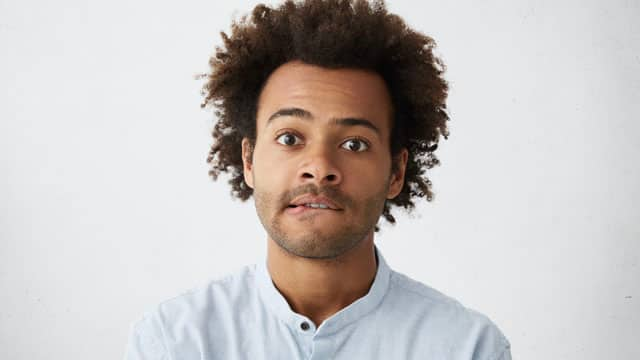 Un hombre mordiendose el labio inferior