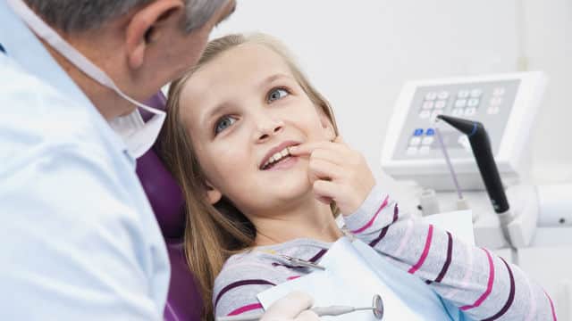 girl patient showing her teeth to the dentist