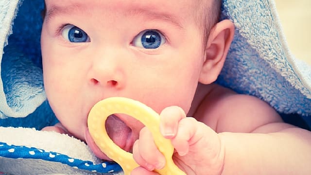 a toddler is using a teething ring