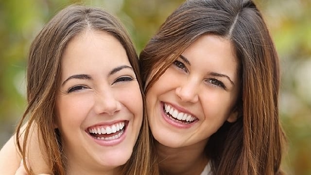 two girls are smiling with new pit and fissure sealants