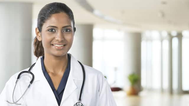 a female doctor smiling with a stethoscope