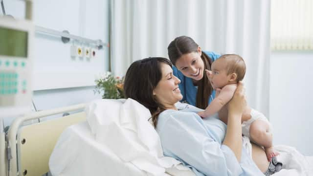 Madre sonriendo al ver a su bebé