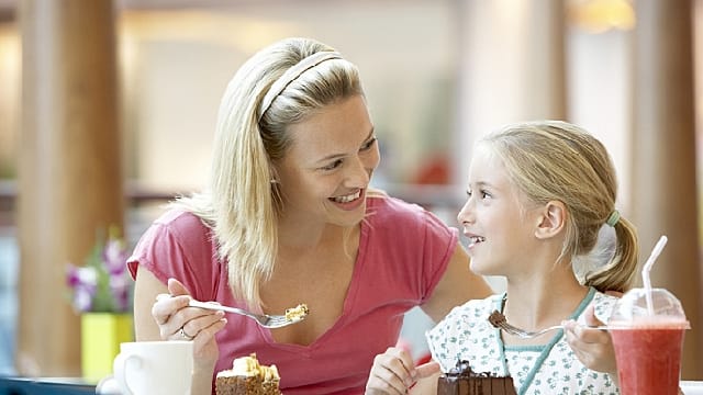 mother and daughter are eating cake after dental clinic visit