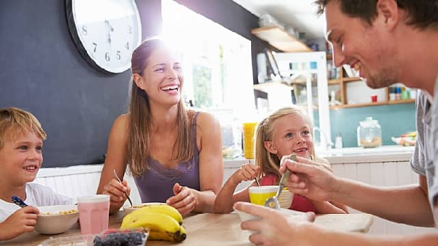 Padres e hijos desayunando en familia