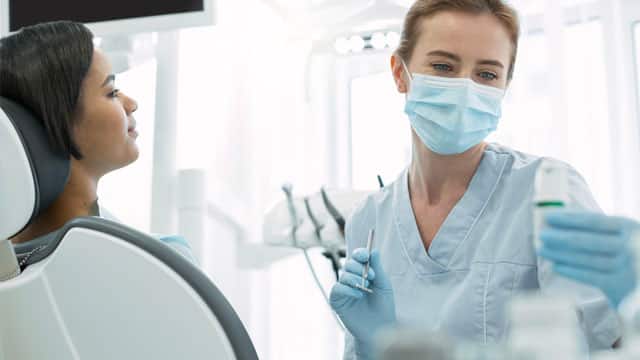 A patient being examined by a dentist in a dental chair.