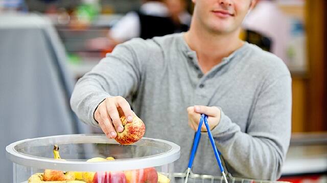 a man is picking up high alkaline foods in store