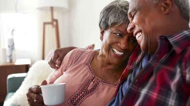 middle-aged couple cuddling and smiling 