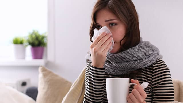 Girl suffering of cold and having stuffy nose