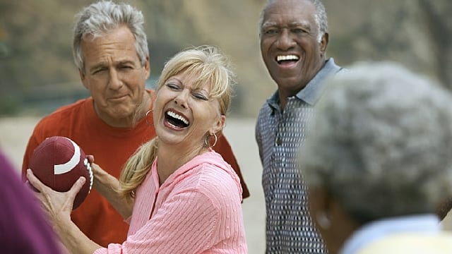 Grupo de adultos mayores jugando y sonriendo