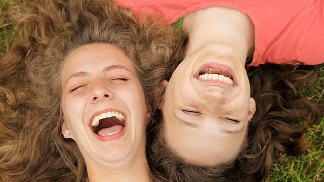 two young girls are smiling together after removing retainers