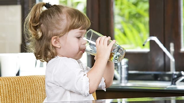 Niña tomando agua fluorada fria