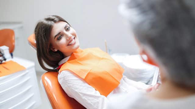 A young woman sitting in a dental exam chair.