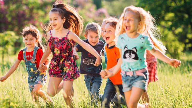 A group of children running and playing in the park.