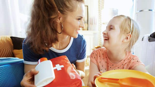 A mother and a daughter with a first aid kit.