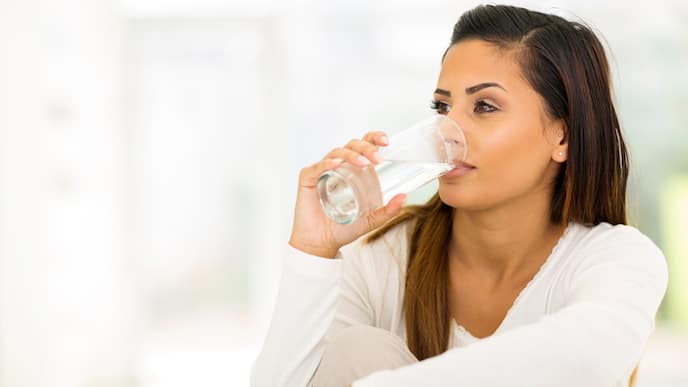 a woman drinking a glass of water