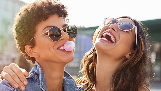 Amigas riendo y comiendo chicle