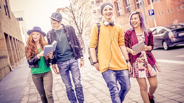 A group of student smiling brightly while walking