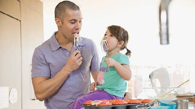 Father and daughter baking cupcakes in the kitchen