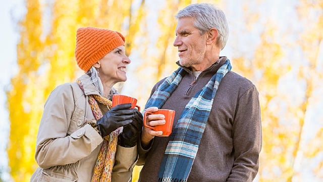 an older couple smiling while drinking tea outdoor