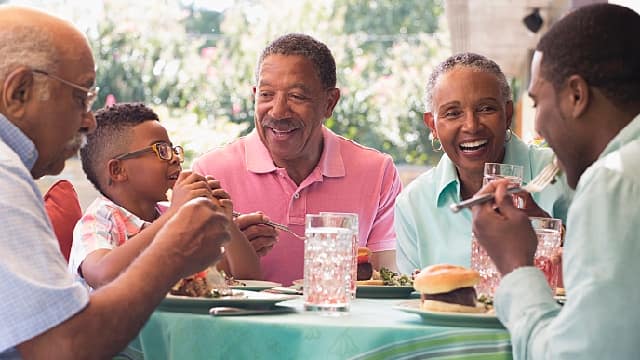 Familia sonriendo mientras come