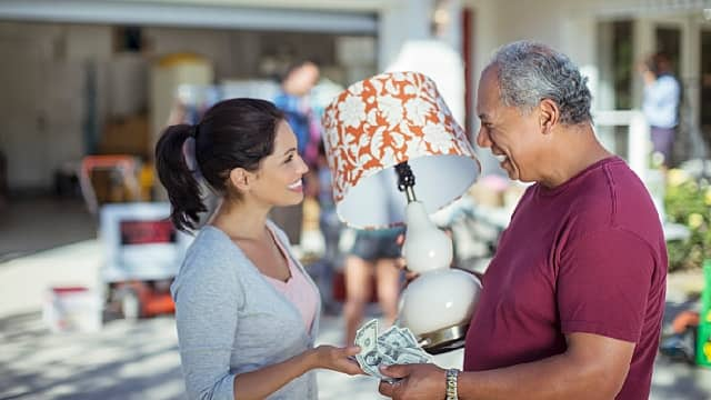 a woman is buying a lamp from a seller after root canal treatment