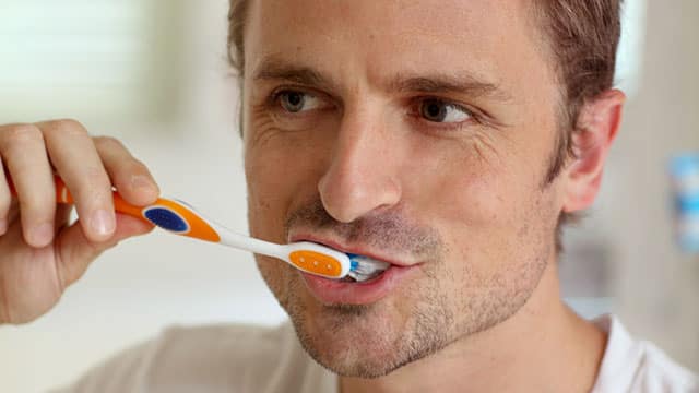 A man is brushing his teeth