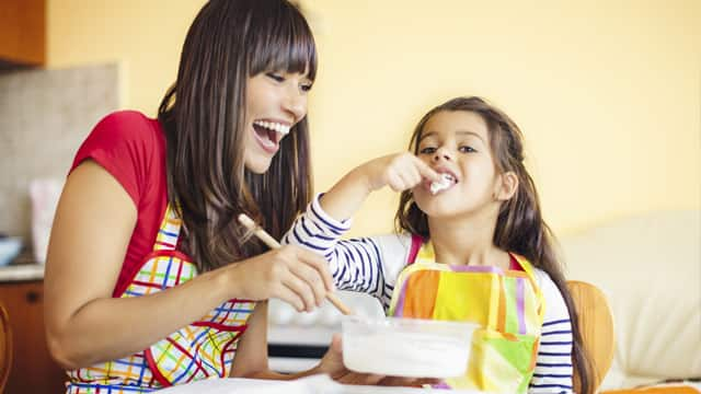 mother and daughter smiling while baking