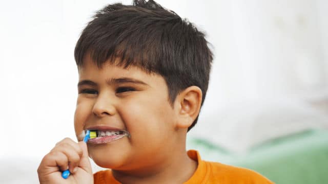 Boy brushing his teeth before using mouthwash