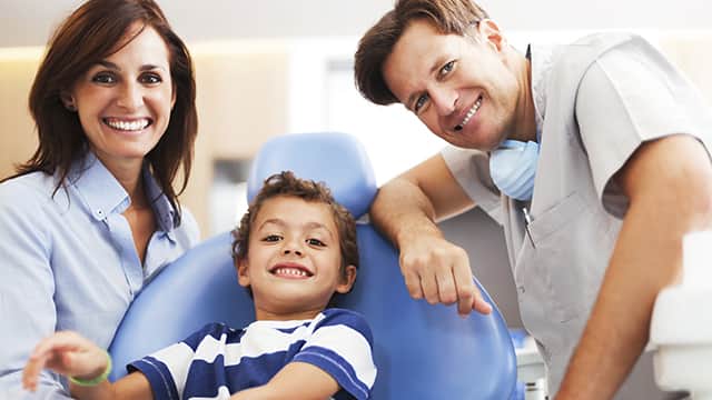 mother and son are in the dentist office with pediatric dentist