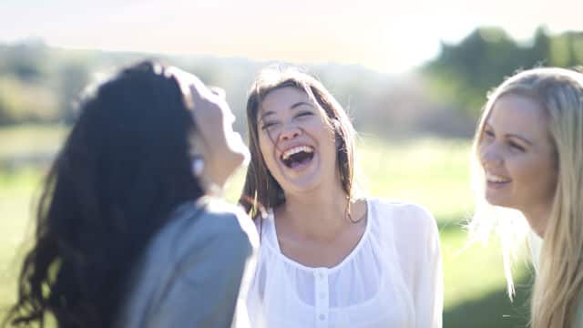 Three girls laughing together outdoor