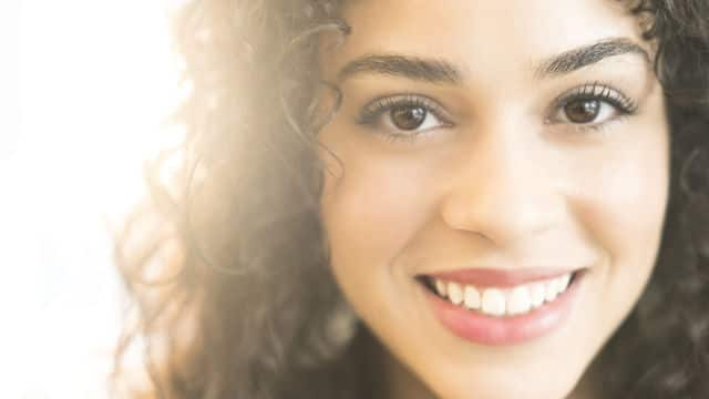 Mujer sonriendo con dientes brillantes y blancos