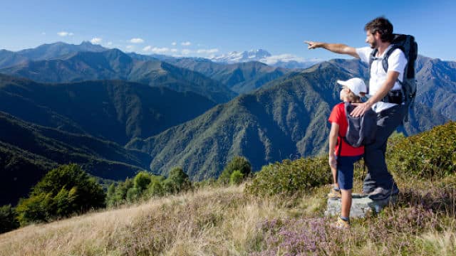 a father and son hiking and pointing to the mountain