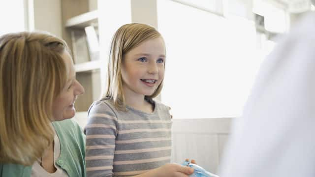 young girl and her mother are meeting dentist in the office