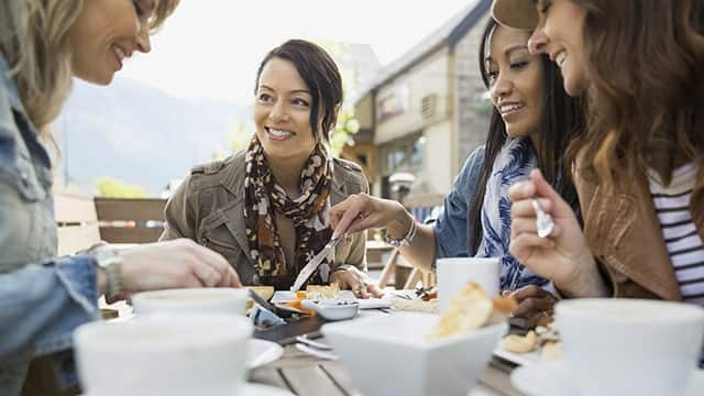 a group of women smiling while enjoying brunch