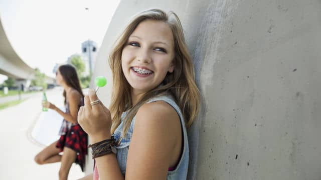 Niña con brackets comiendo dulces