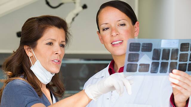 Dentist reviewing a dental x-ray with her assistant