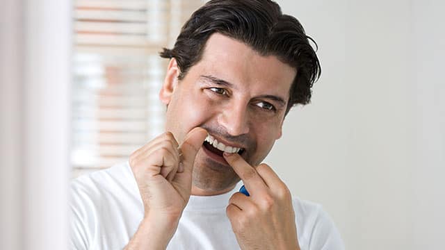 Male model flossing his teeth