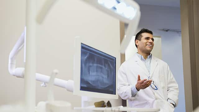 Happy Dentist explaining to unseen person what Cerec is.