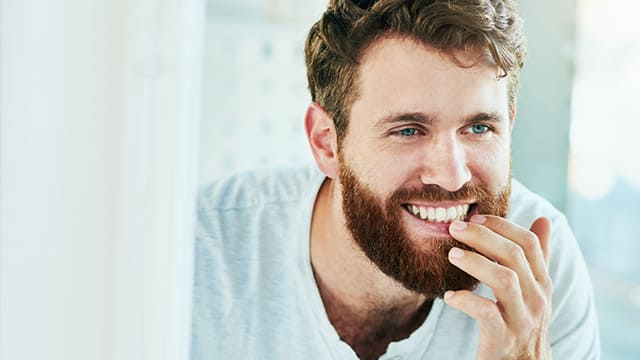 Young bearded man checking his teeth