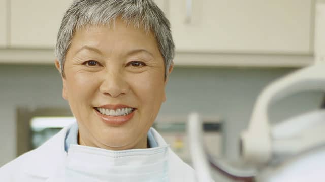 Mujer mayor sonriente en el consultorio dental