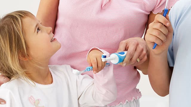 Mamá enseñándole a sus hijos a lavarse los dientes