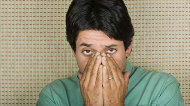 man covering his nose and mouth