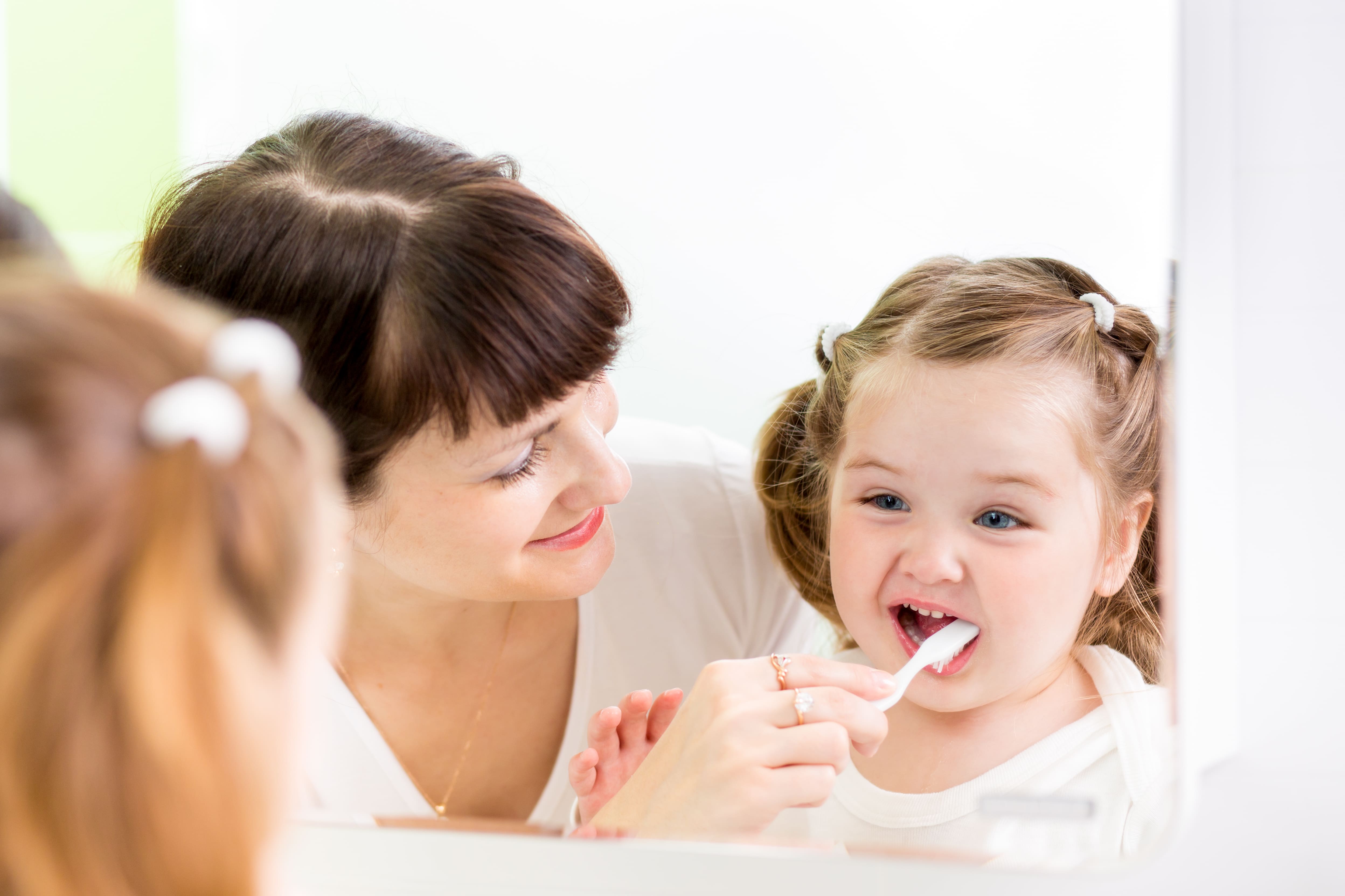 Mother  brushing kid's teeth