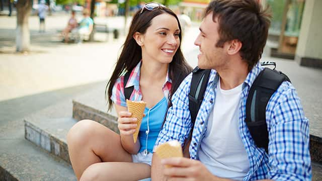 A young couple eating ice cream outdoors