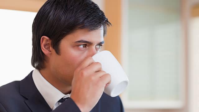 A man is drinking from a cup