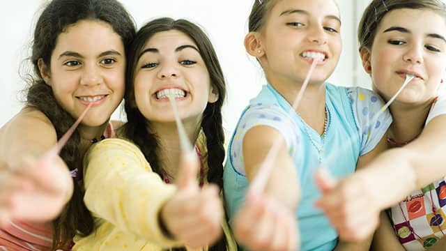 Four girls are pulling chewing gum