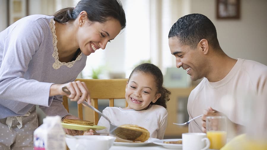 a happy family is having healthy breakfast together as a way to avoid morning breath