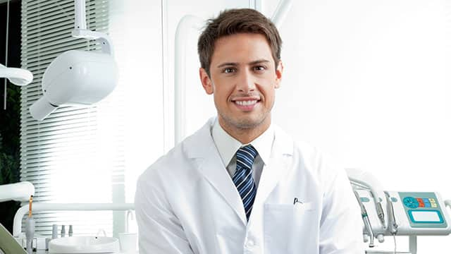 A portrait of a male dentist in his office