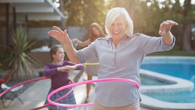 An older woman hula hooping outdoors An older woman hula hooping outdoors